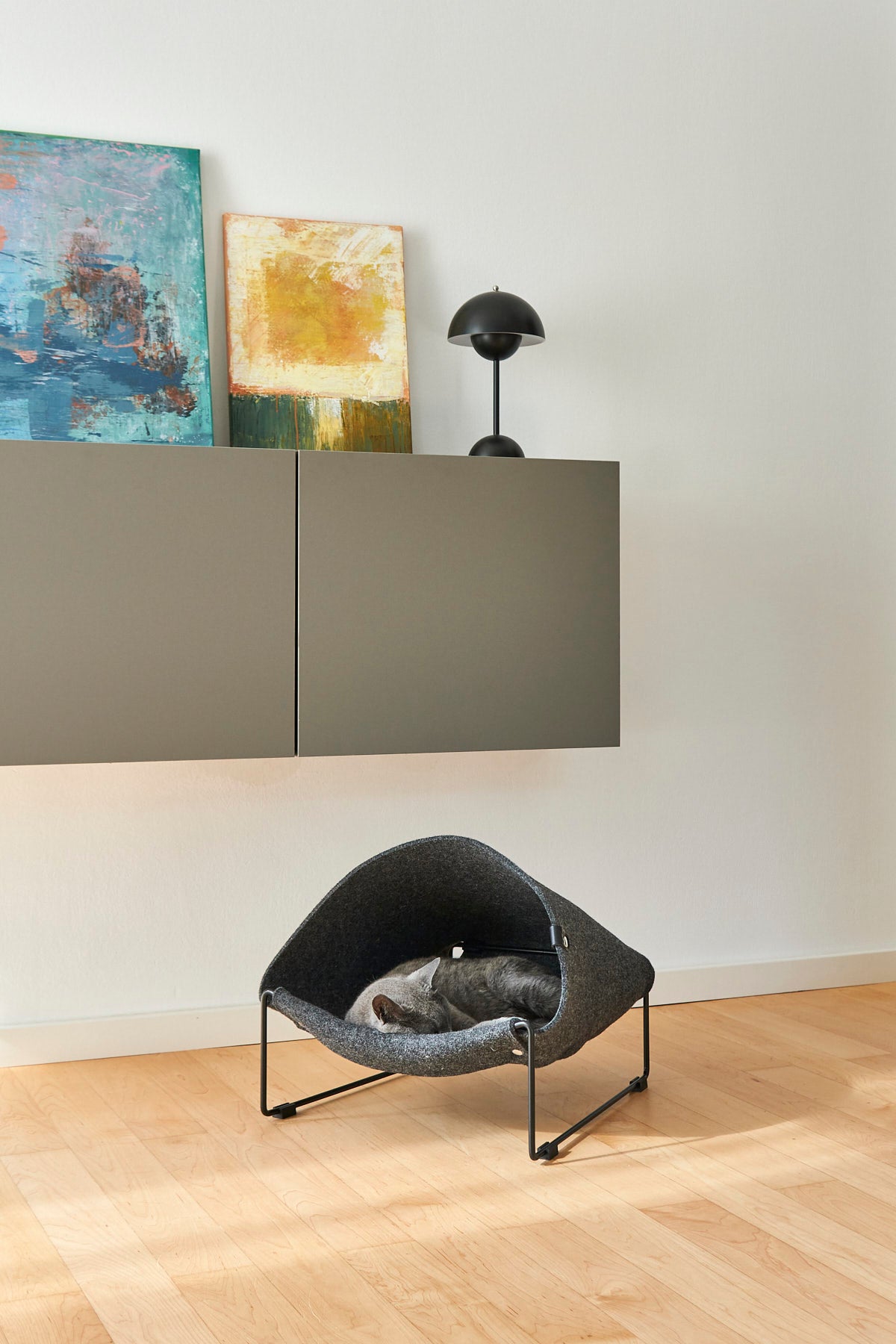 Cat lounging inside MiaCara Loggia felt cat cave in grey, modern raised hideaway with cozy enclosed design.