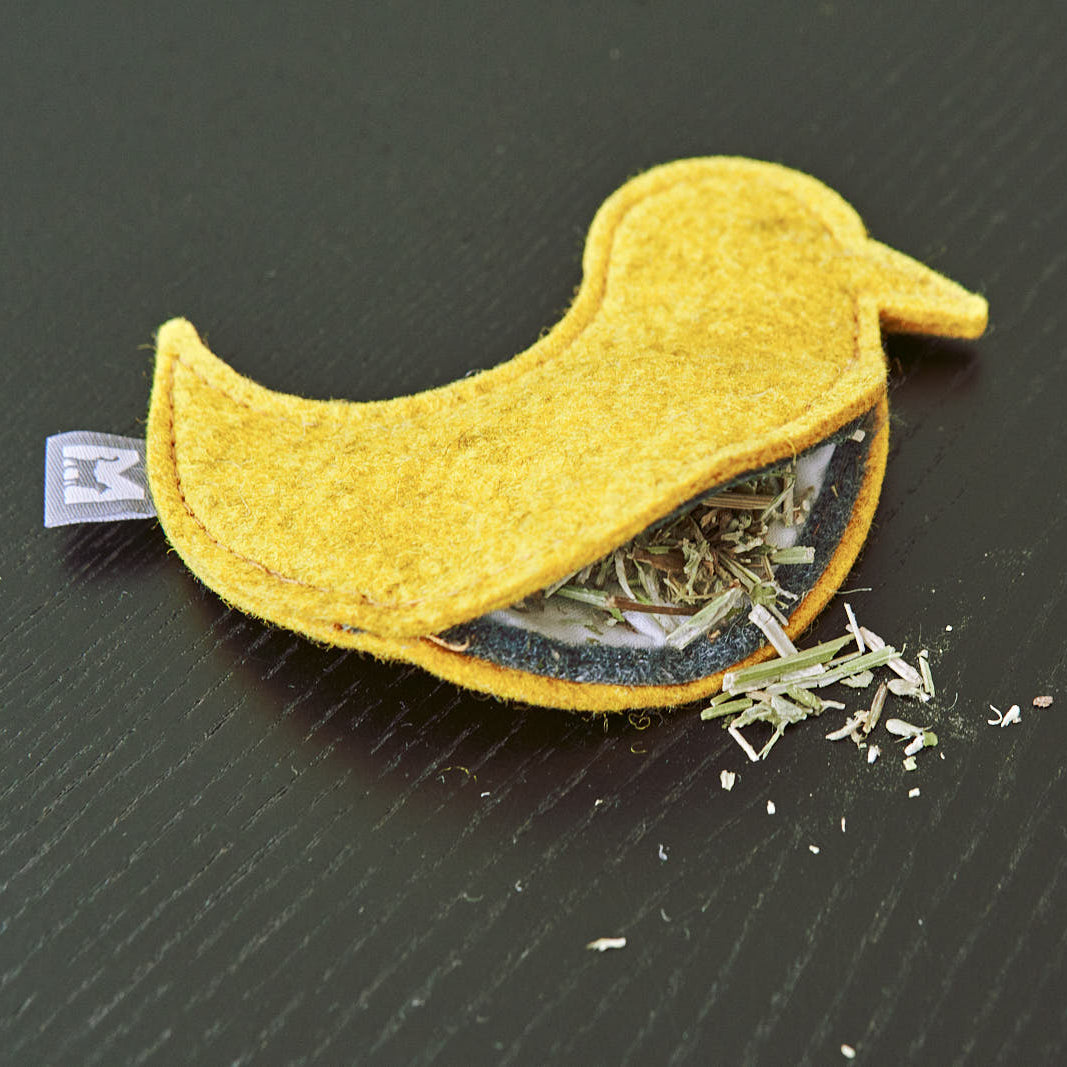 Close-up of MiaCara yellow felt catnip toy in bird shape, showing stitching and refillable pouch tag.
