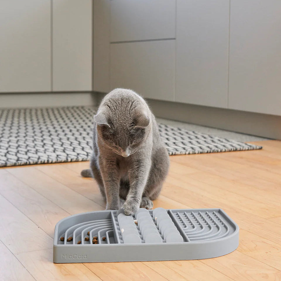 Cat  playing with MiaCara Aperitivo interactive slow feeder in grey, designed to promote healthy, engaging feeding habits.