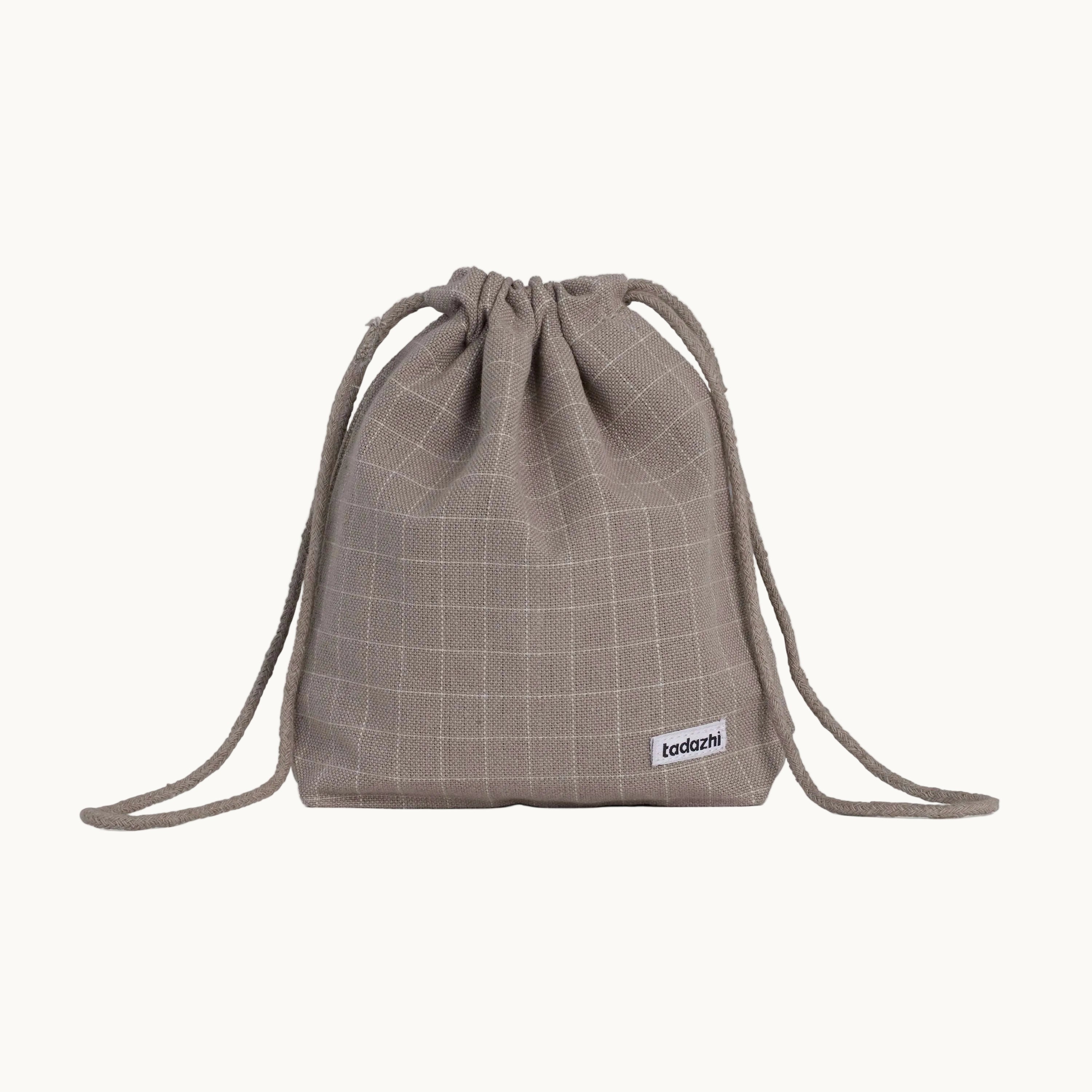 Minimalist dog treat bag in chequered dark sand fabric with drawstring closure, part of Tadazhi x Lumi Pets Walk collection.