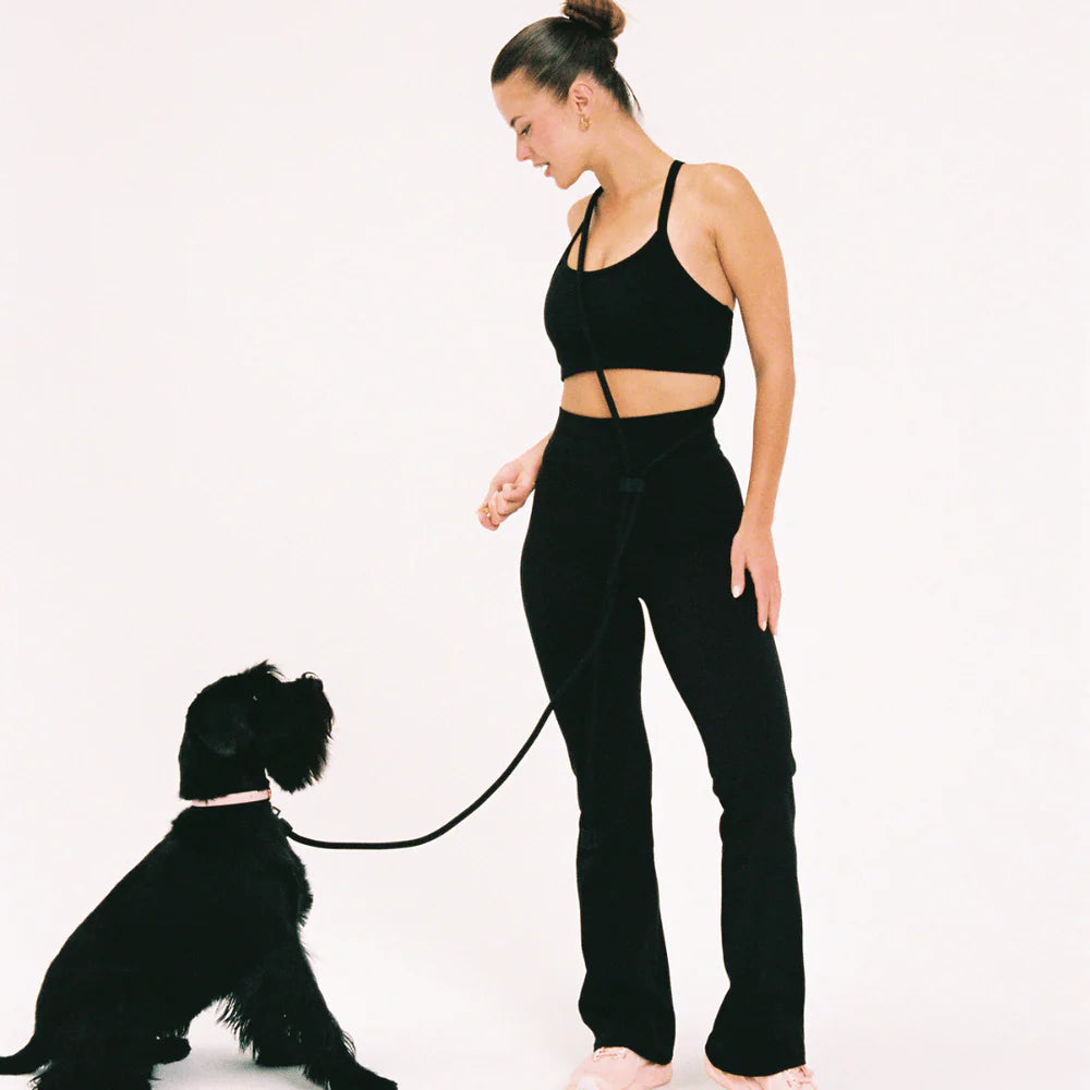 Dog owner using black hands-free dog lead cross-body style, practical and comfortable walking accessory.