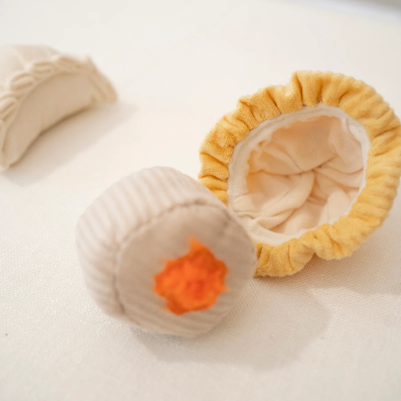 Close-up of Lambwolf Collective Dimsum Pop plush toy, textured fabric dumpling design with removable ball.