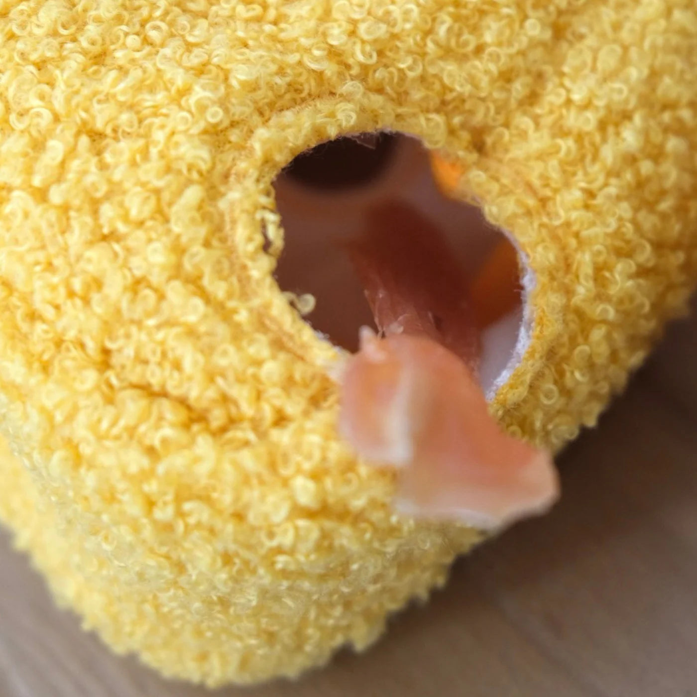 Close-up of Lambwolf Collective Fromage cheese toy, yellow plush fabric with playful hollow holes