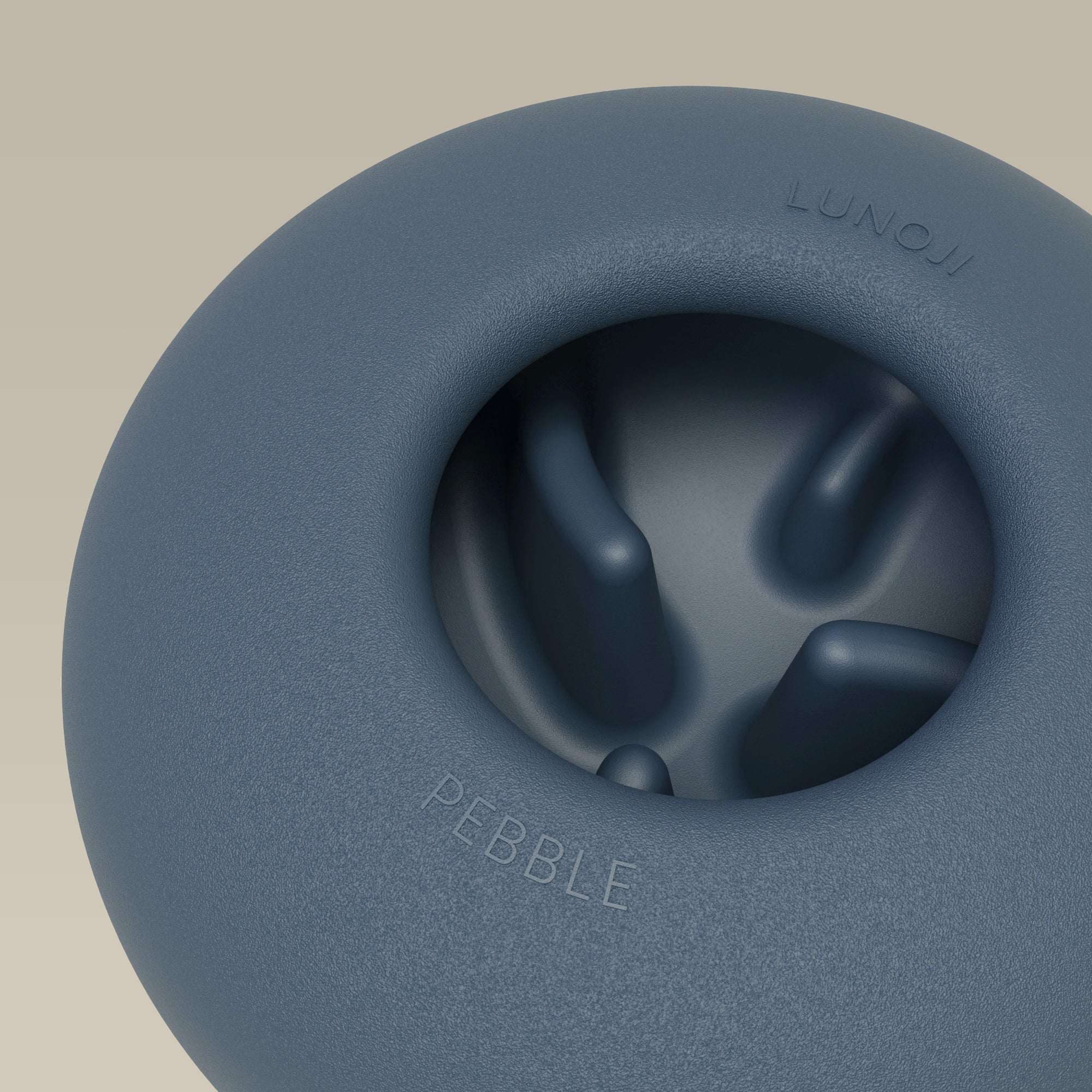 Close-up of Lunoji Pebble interactive dog toy in blue showing treat-dispensing hole and smooth silicone finish