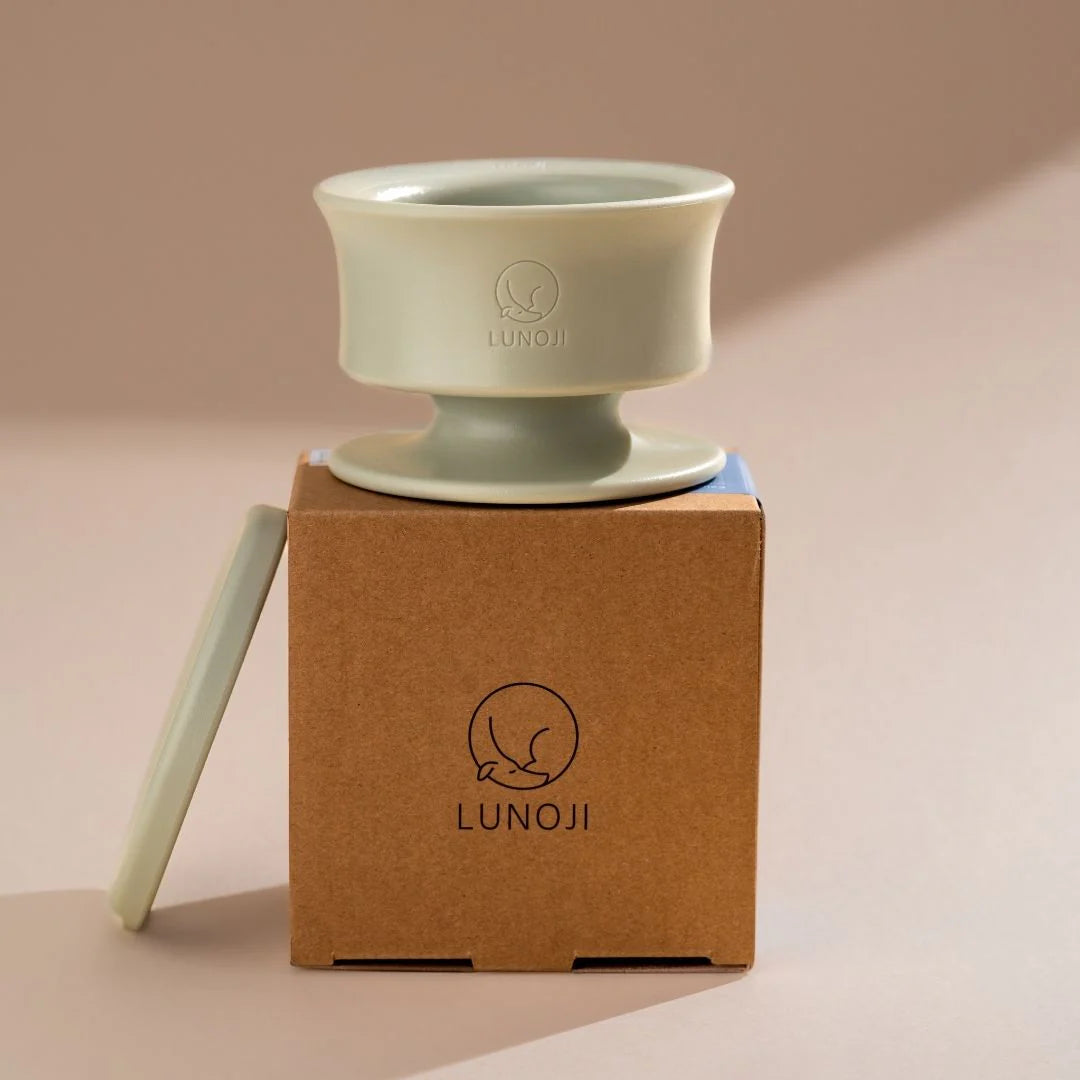 Lunoji Trove slow feeder in sage green placed on branded kraft box, minimalist elevated design made from food-grade silicone for enrichment feeding