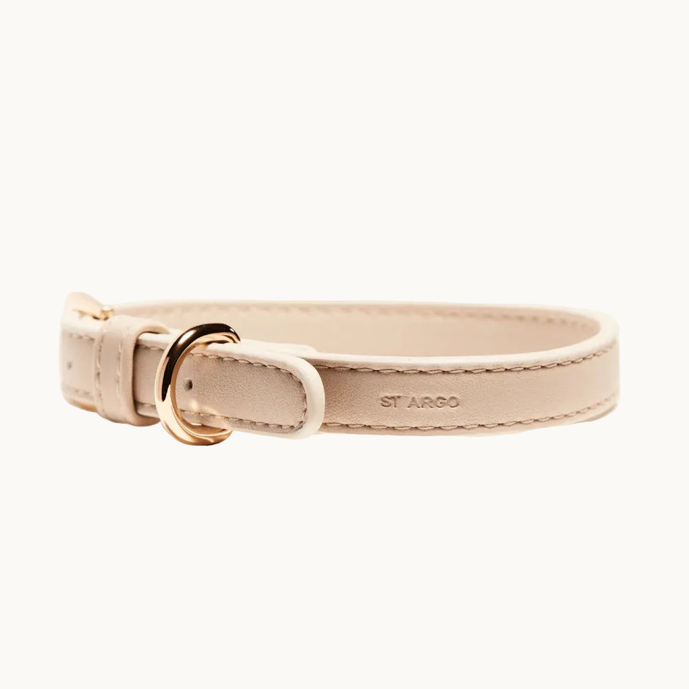 Close-up of vegan leather dog collar in beige, showing smooth finish, stitching, and gold buckle.